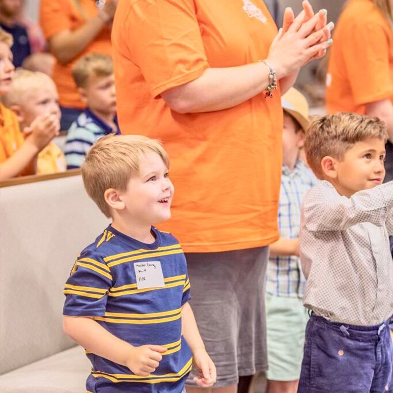 An image of children clapping and singing at Lighthouse Baptist Church's VBS in Theodore, AL.