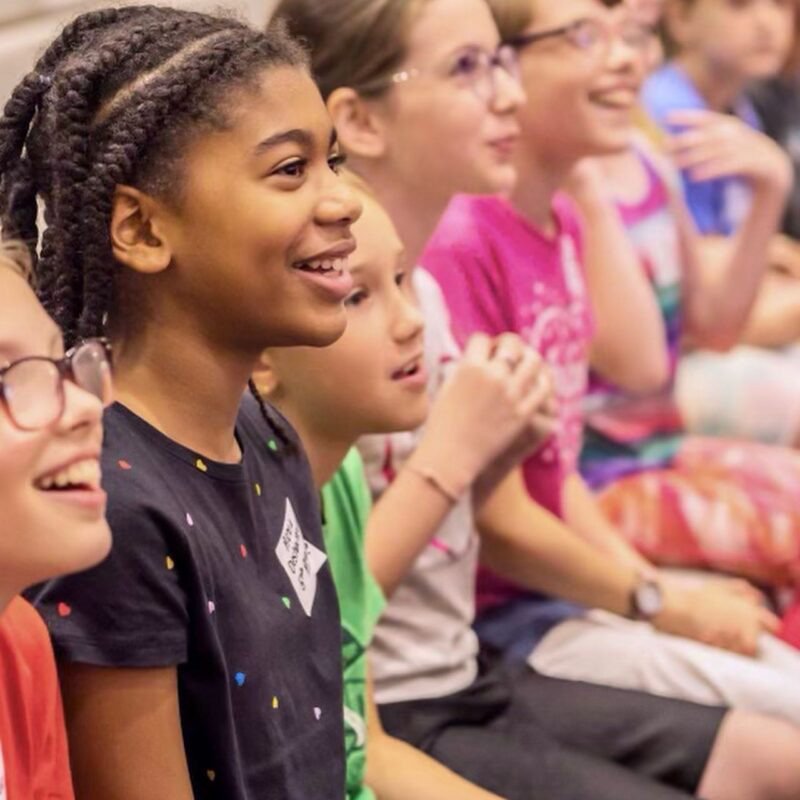 An image of children clapping and singing at Lighthouse Baptist Church's VBS in Theodore, AL.